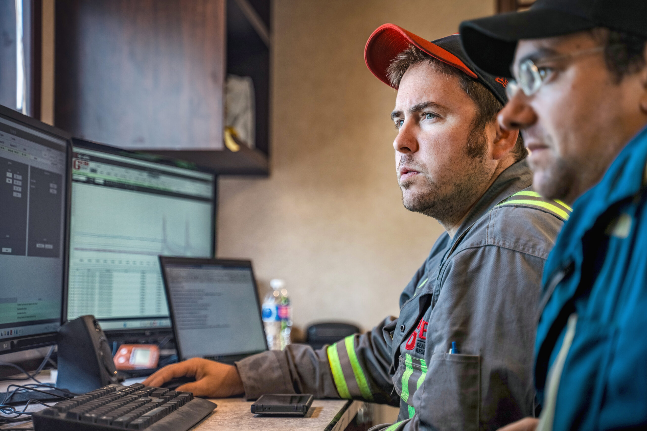close up portrait of two SCADA operation technicians looking at computer